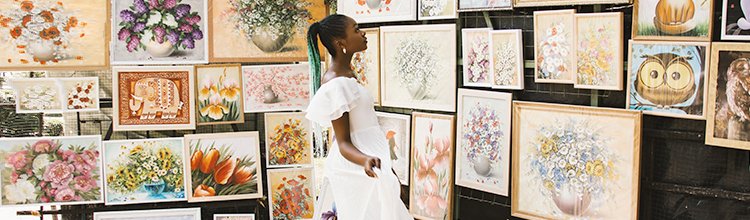 A woman inspects art at a show.
