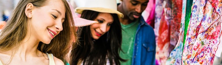 Friends enjoy their shopping at an outdoor vendor.