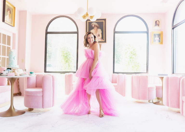 Danielle Phillips wearing her custom earrings and posing in a pink dress