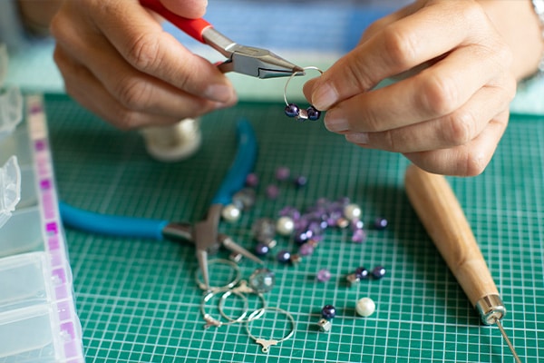 A crafter makes jewelry.