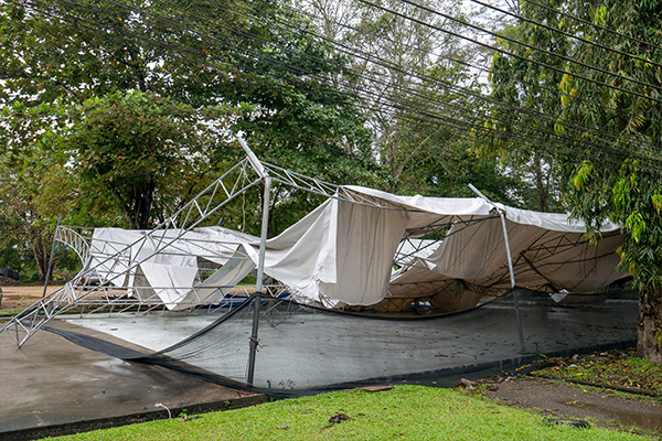 A large white tent suffers has collapsed under rain and wind damage, but the business owner may be covered by artist insurance.