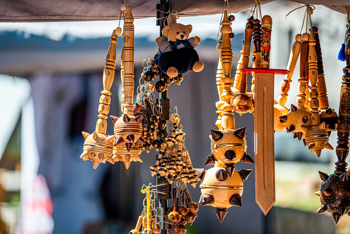 A vendor's handcrafted wares hand on display at a festival.