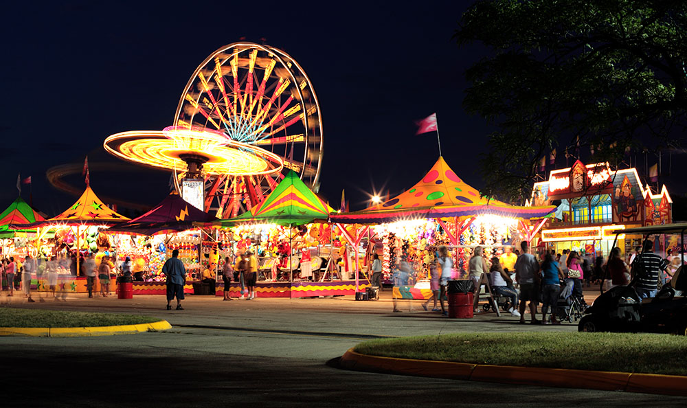 A city event with tents and booths at night.