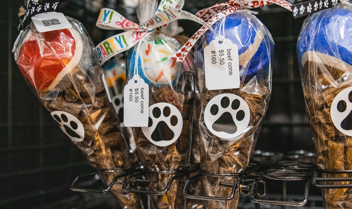 Handmade dog treats are arranged in cone shaped bags with a tennis ball on top in the FurReal Tasty Treats booth.