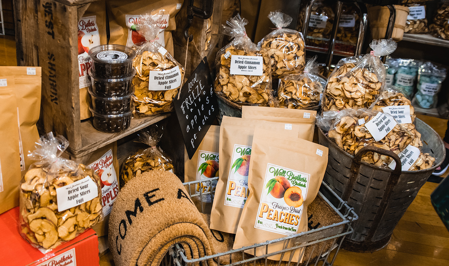 Dried apples, welcome mats, and other farm house decor sit on display in the Wall Brothers Orchards booth.