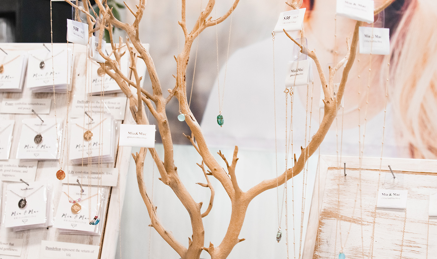 Handmade jewelry is hung on the branches of a small display tree in the Mia and Mac booth.