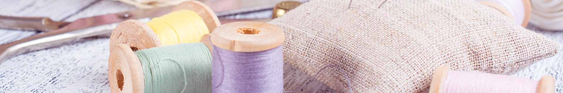 Craft materials such as yarn and needles lays on a desk.