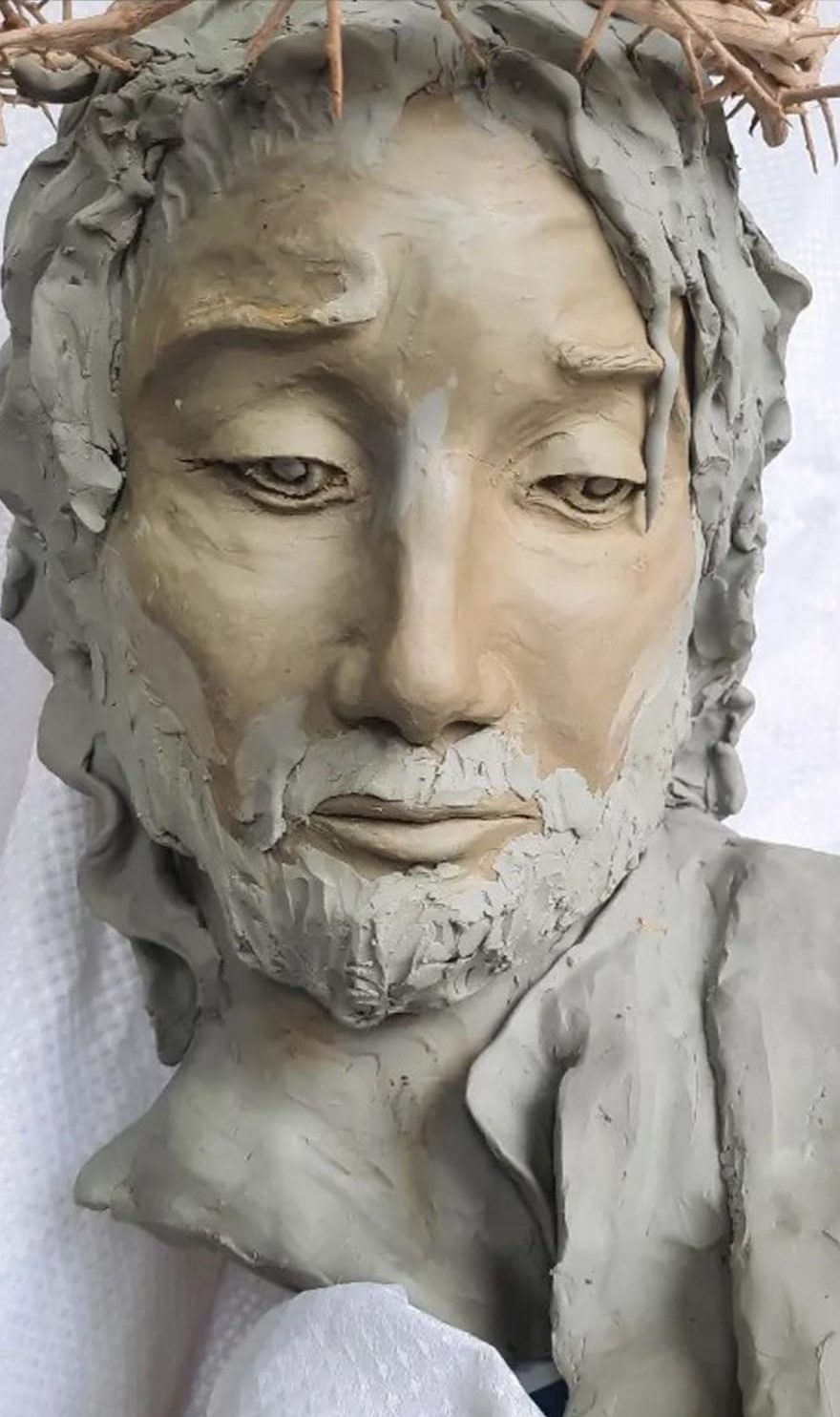 A clay bust of Christ with a crown of thorns awaits to be glazed and fired into a bronze bust.