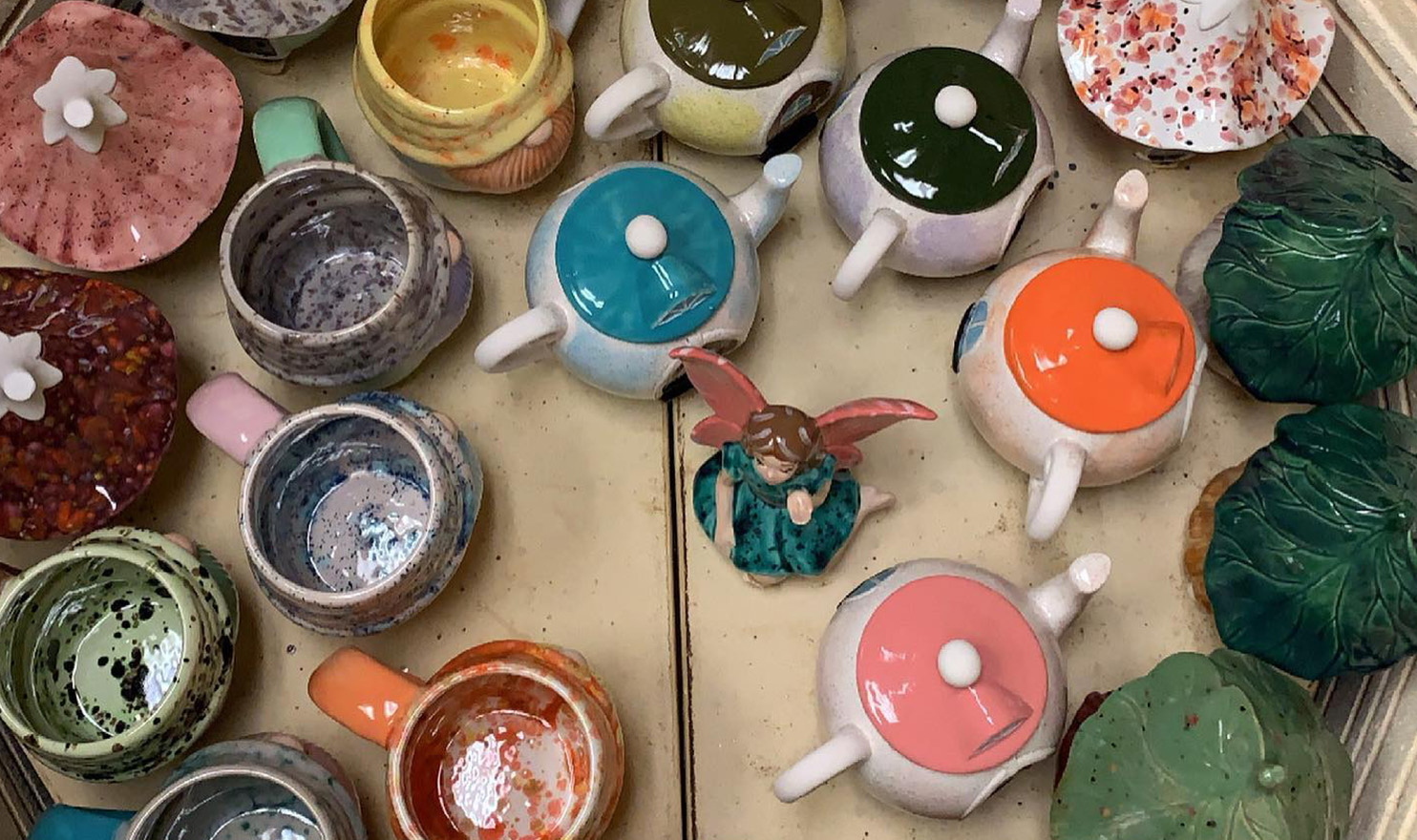 A variety of colorful, hand painted pottery items sit in the kiln after being glazed and fired.