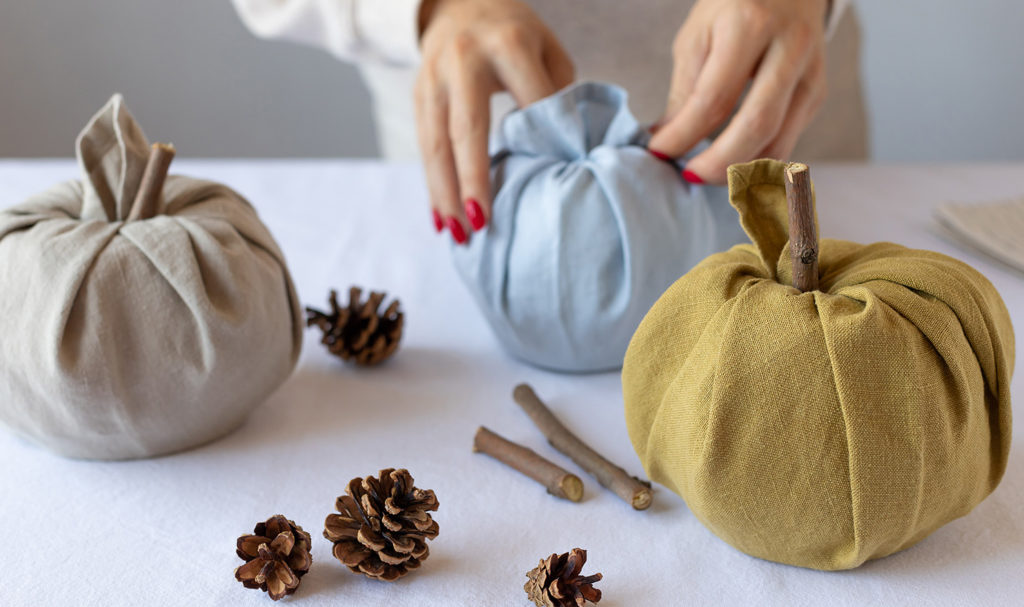 A pair of hands are making homemade pumpkin decor for the fall.