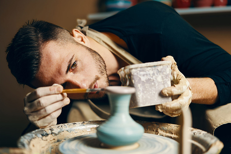 A potter works on a spinning wheel.