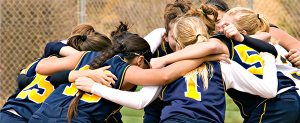 A group of Youth huddle before a softball game.
