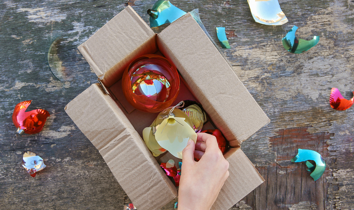 A box of broken handmade ornaments that were damaged during shipping.