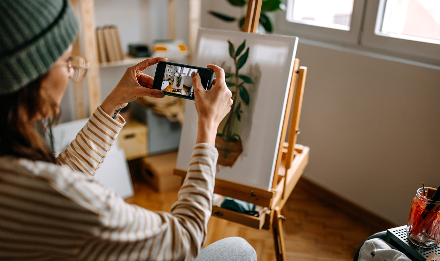 An artist is taking a photo of their latest piece of work for their website.