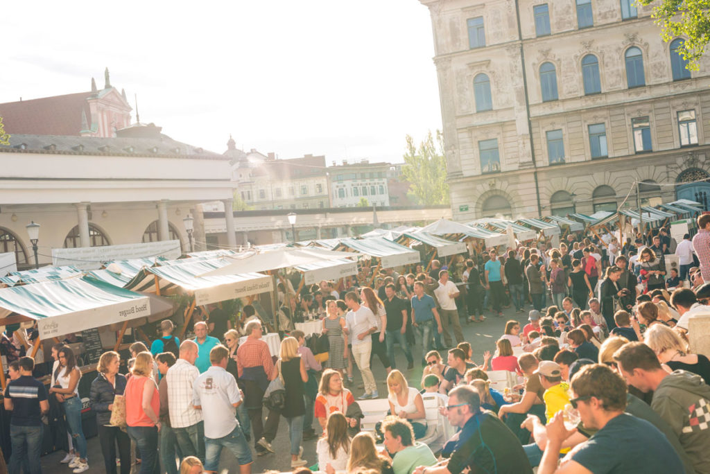 An overhead view of an outdoor market taking place in a city center.