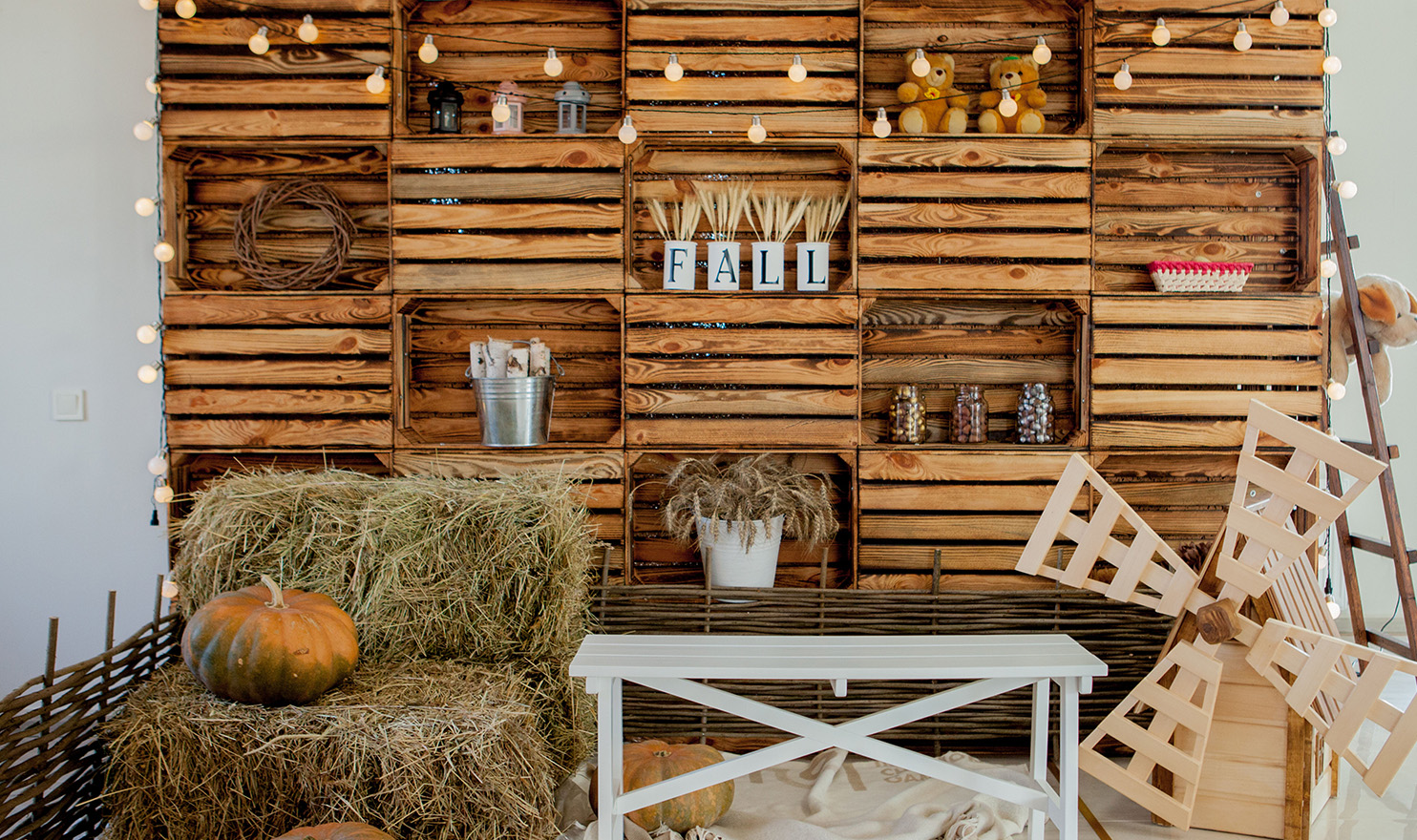 A wall of wooden boxes has been transformed into a creative display for a vendor booth at an event. Products are on the shelves and around the front of the wall. Using wooden crates is one of many cheap trade show booth ideas to help you boost sales.