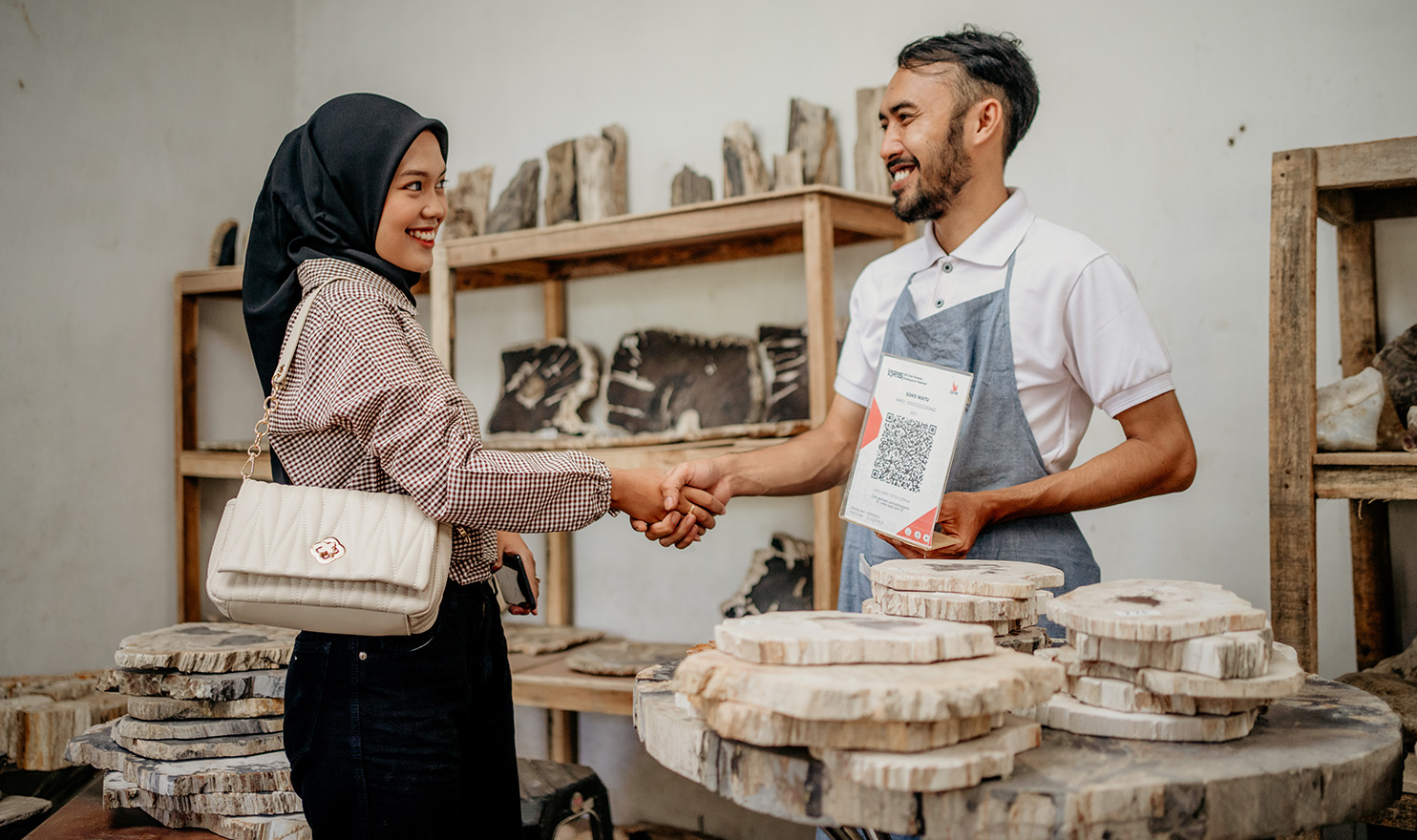 A customer is making a purchase from a vendor. Using captivating trade show booth ideas helps vendors to attract customers.