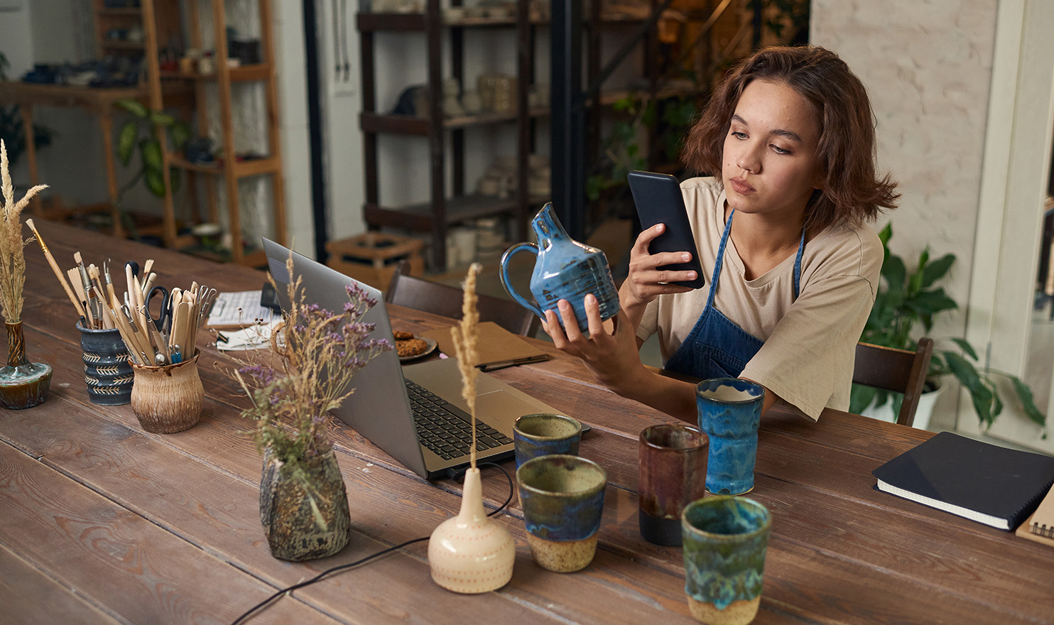 A crafter is taking photos of their latest piece inside their studio so they can upload it to their website.