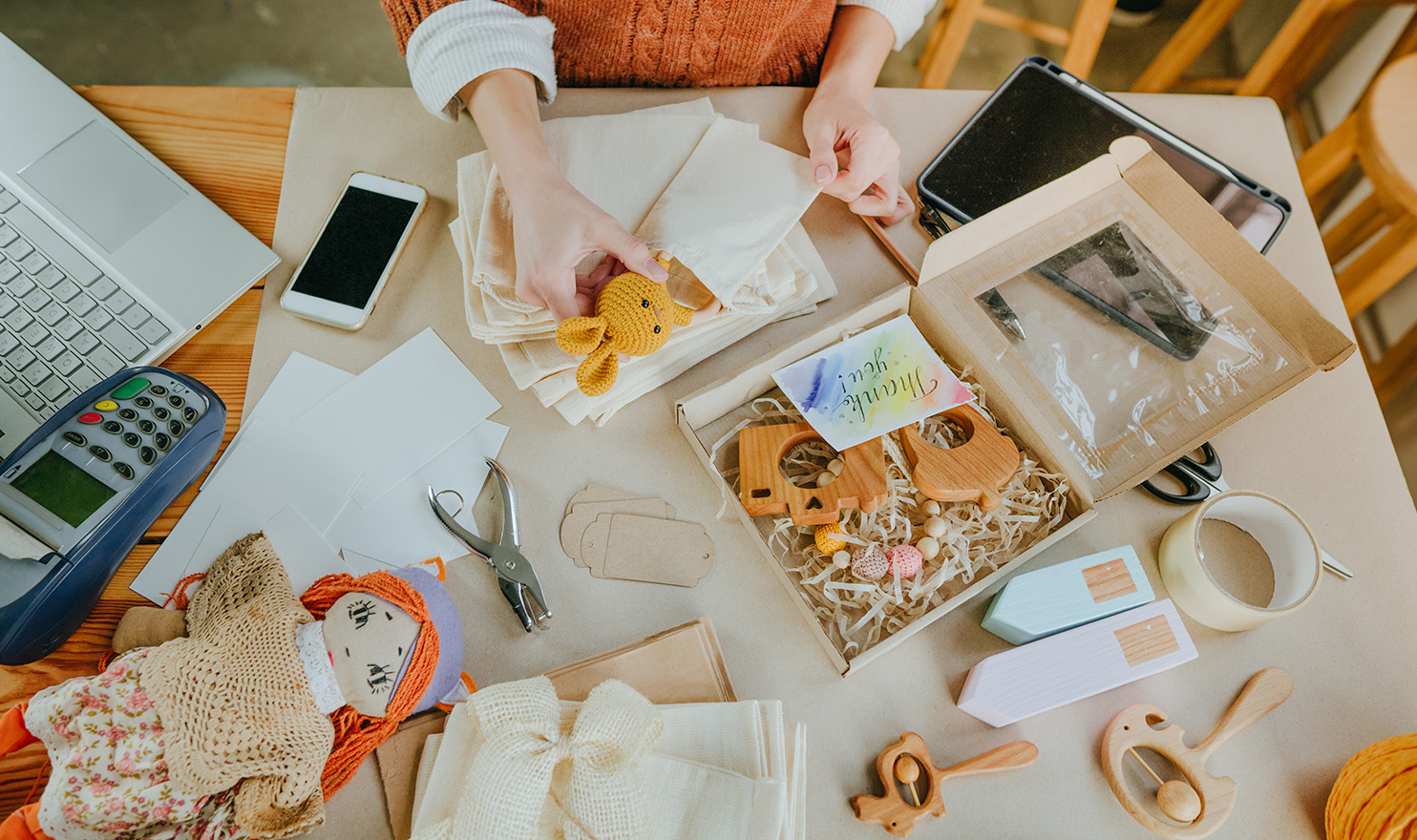 A crafter is preparing a box of fun products to mail to a social media influencer to help boost her sales.