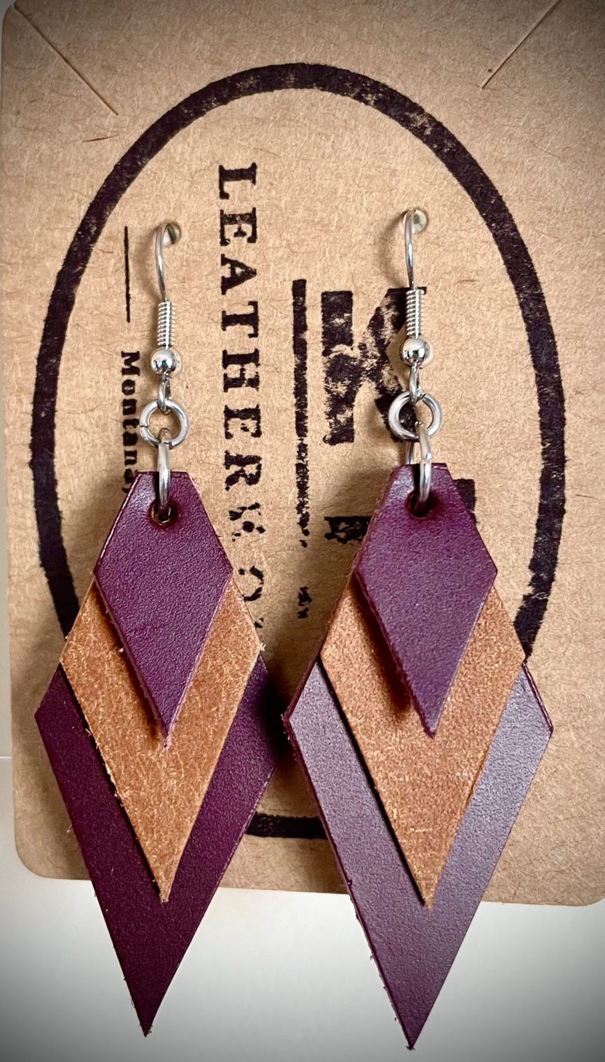 A pair of leather earrings Kelsey handcrafted show a unique diamond shape made from different types of leather.