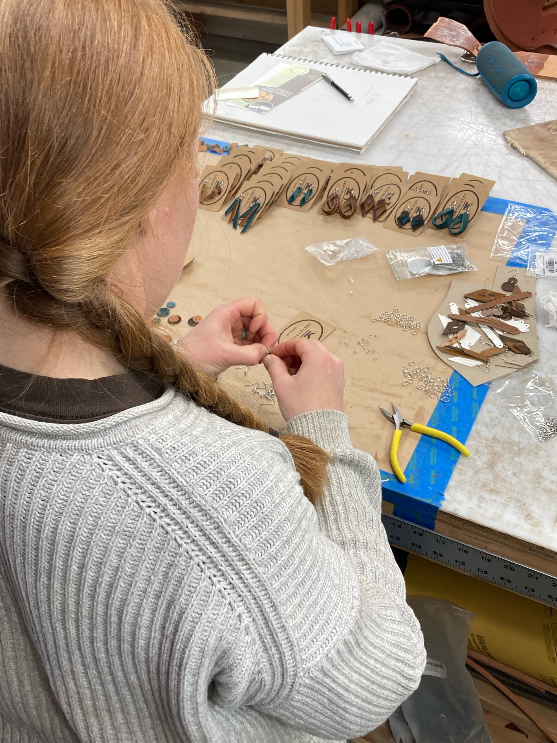 Kelsey working in her studio on handcrafted leather items.