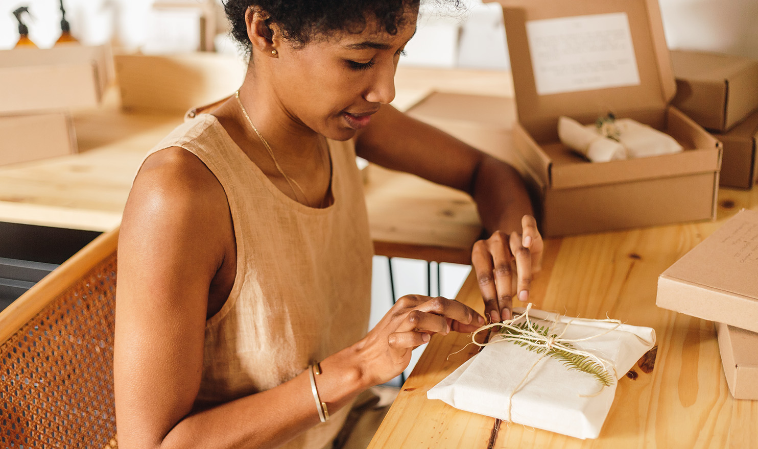 An artisan is carefully packaging an order with little added touches to make it feel special.